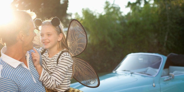 Father holding daughter in fairy wings