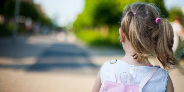 Toddler girl with backpack going to school with two ponytails