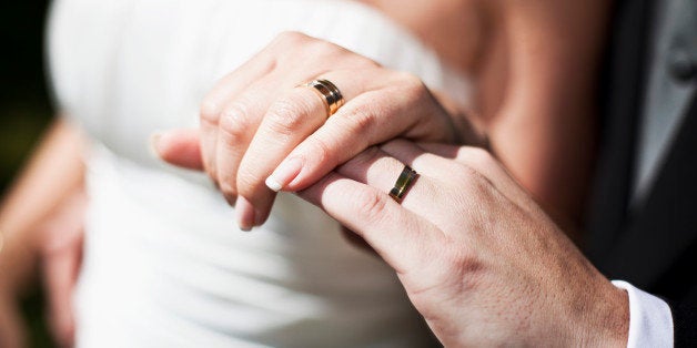 Hands of bride and groom showing their wedding rings