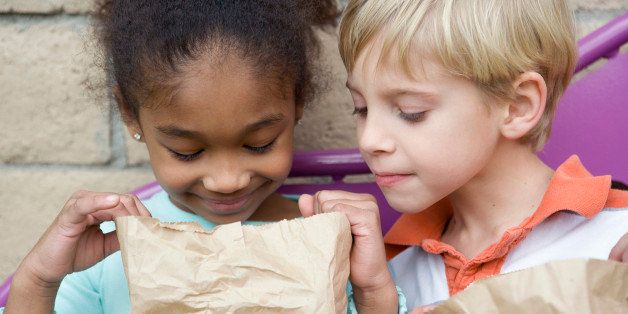 Boy looking in friends lunch bag at recess
