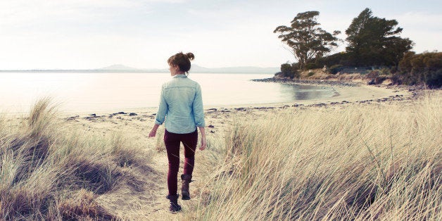 Woman walking onto beach in winter