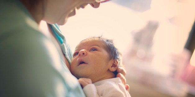 Mom smiling at newborn at hospital