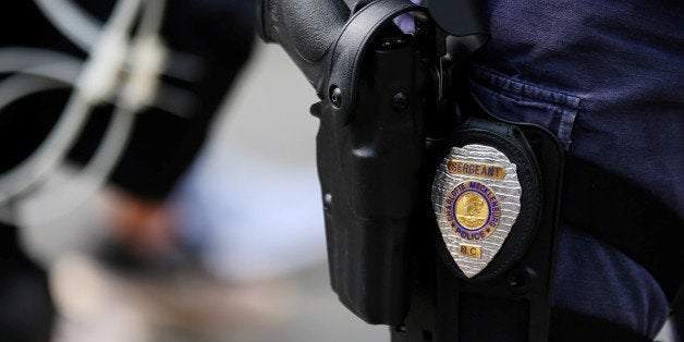 The badge and gun of a Charlotte police officer in riot gear are seen during a large security presence outside the football stadium as the NFL's Carolina Panthers host the Minnesota Vikings amid protesting of the police shooting of Keith Scott in Charlotte, North Carolina, U.S., September 25, 2016. REUTERS/Mike Blake