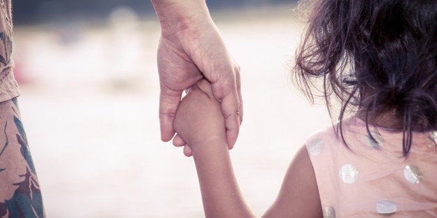 child cute little girl and mother holding hand together with love in vintage color filter