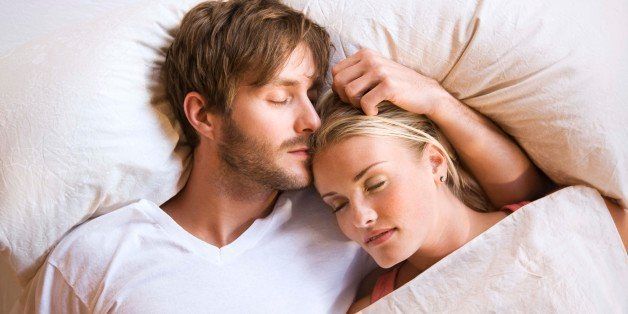 Couple cuddling and sleeping in bed