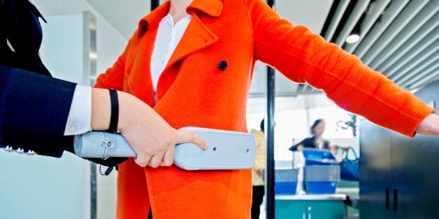 airport security check using a metal detector on a passenger.