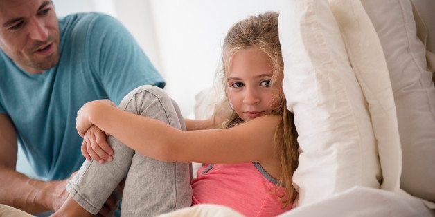 Father talking to daughter (6-7) in bedroom