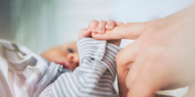 Mother holding her baby hand