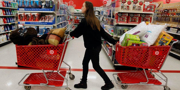 A woman pulls shopping carts through the aisle of a Target store on the shopping day dubbed "Black Friday" in Torrington, Connecticut November 25, 2011. The U.S. holiday shopping season was in full-swing on Thursday, with retailers hoping consumers will spend big despite worries about the fragile economy and their own precarious finances.To narrow the gap in store hours with rivals, discounter Target Corp electronics chain Best Buy and department store chains Macy's Inc and Kohl's Corp will open at midnight, their earliest starts ever. REUTERS/Jessica Rinaldi (UNITED STATES - Tags: BUSINESS)