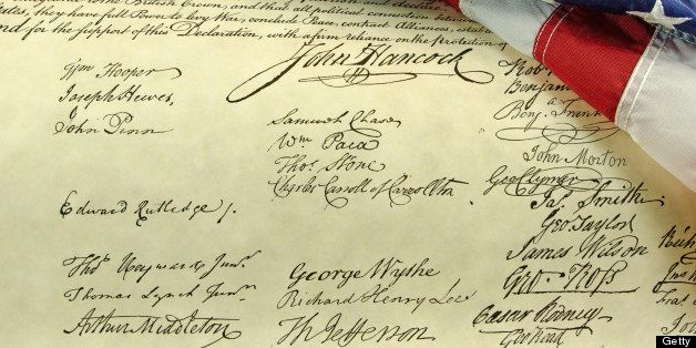 An American flag close-up and folded and place on the signatures on the Declaration of Independence.