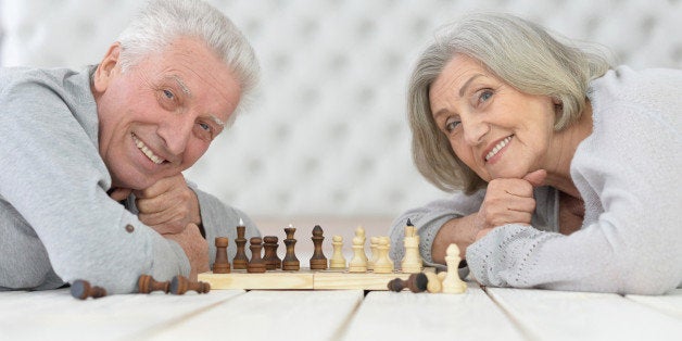 happy Senior couple resting at home and playing chess
