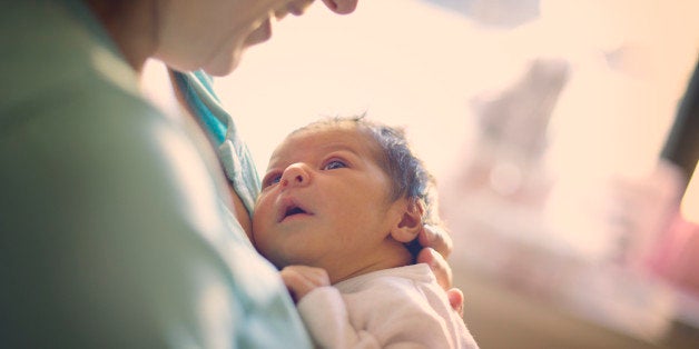 Mom smiling at newborn at hospital