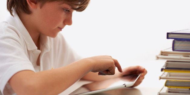 Schoolboy (9yrs) using digital tablet.