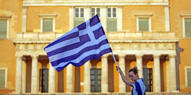 Athens, Greece - June 30, 2011: A Greek woman holds a flag in front of the Greek parliament during a protest in Athens, Greece.