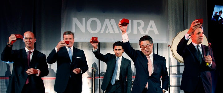 Executives from Japanese bank Nomura celebrate the completion of their acquisition of Lehman Brothers' European operation in