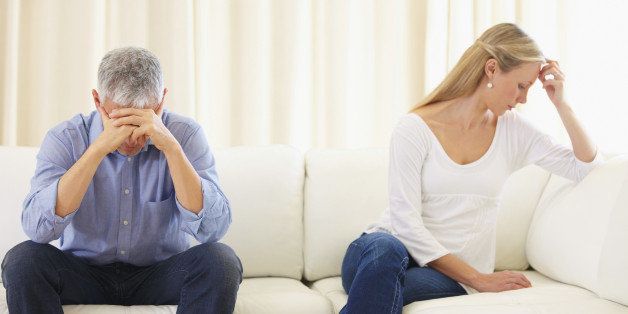 Upset married couple sitting on the sofa after a disagreement