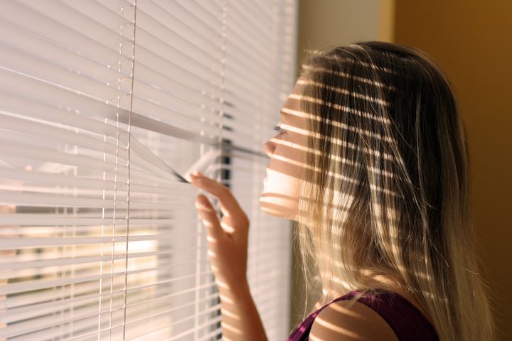 Woman with a shadow from blinds over her face