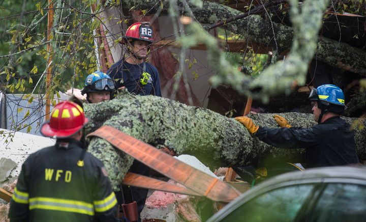 <strong>Firefighters work to remove a tree that fell on a house in North Caroline killing a mother and her child on Friday</strong>