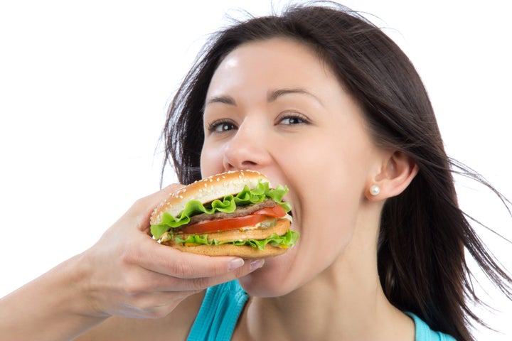 young woman eating tasty fast...