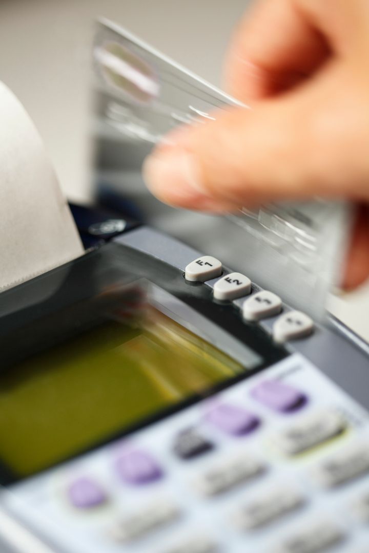 Close up of hand swiping credit card