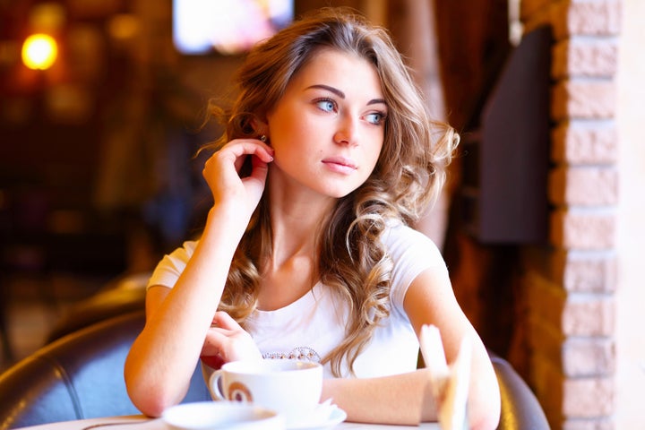 Portrait of young pretty woman sitting in restaurant