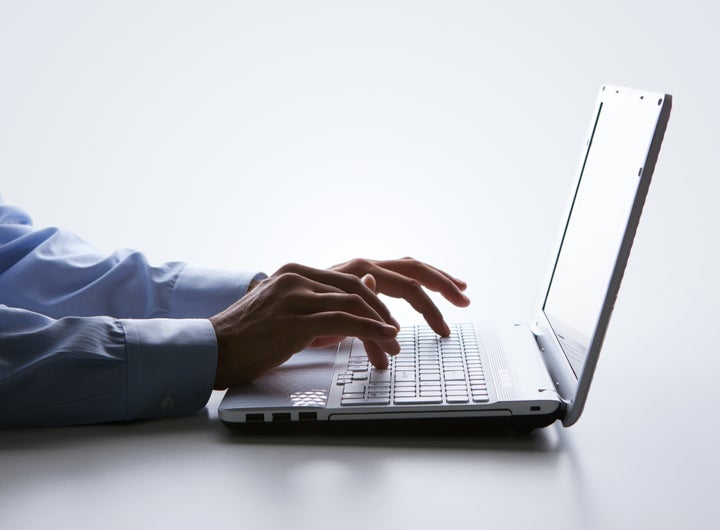 silhouette of male hands typing ...