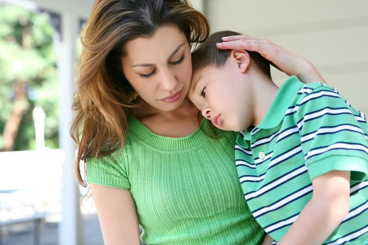 A cute tired boy and his mother on the porch at home showing love