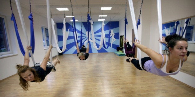 BRATISLAVA, SLOVAK REPUBLIC - OCTOBER 07: People practise AntiGravity yoga or aerial yoga during the fitness classes on October 7, 2011, in Bratislava, Slovakia. AntiGravity Yoga combines traditional yoga principles with elements from aerial acrobatics, dance and pilates. (Photo by Tomas Benedikovic/isifa/Getty Images)