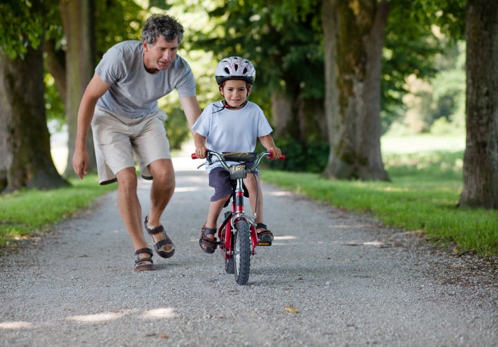 Father teaching his son to ride a bike