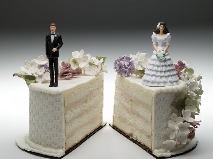 Bride and groom figurines standing on two separated slices of wedding cake