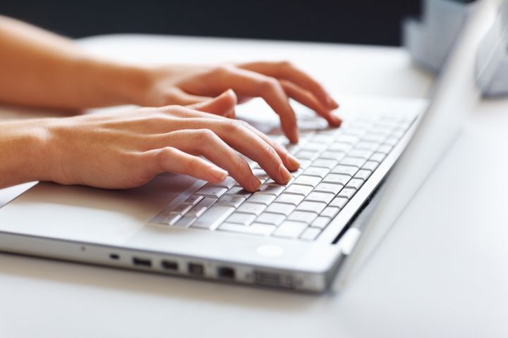 Closeup of business woman typing on laptop keyboard