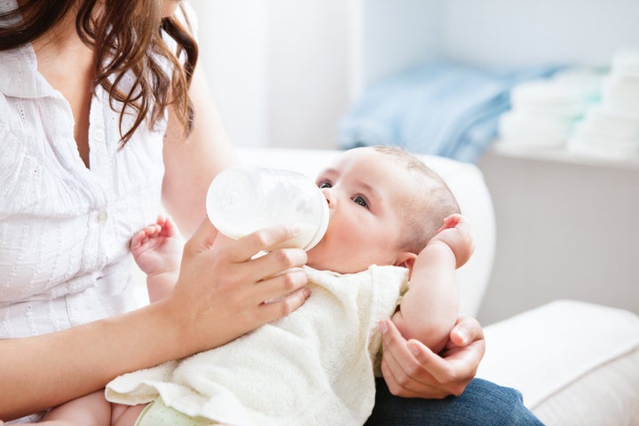 Bright mother feeding her adorable son in the kitchen at home