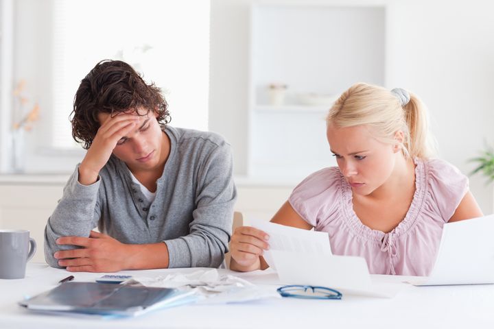 Worried couple doing paperwork in their living room