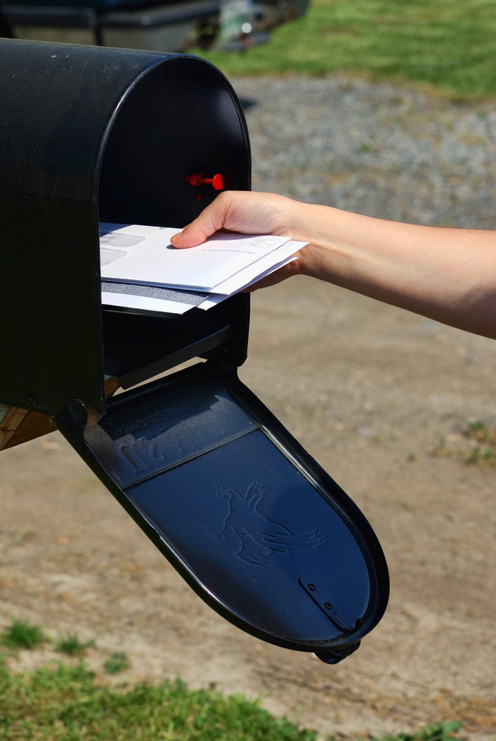 A Person retrieving mail out of a mail box