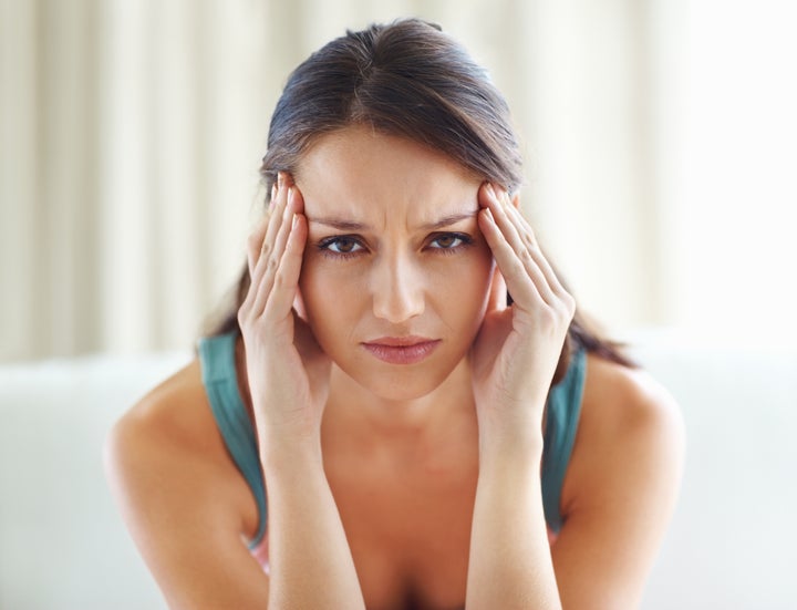 Closeup of beautiful young woman with head pain