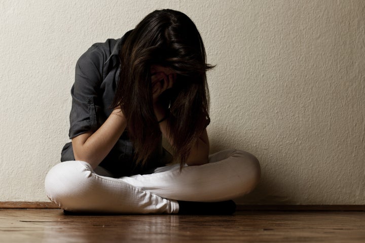 Depressed teenage girl cover the face with her hands.