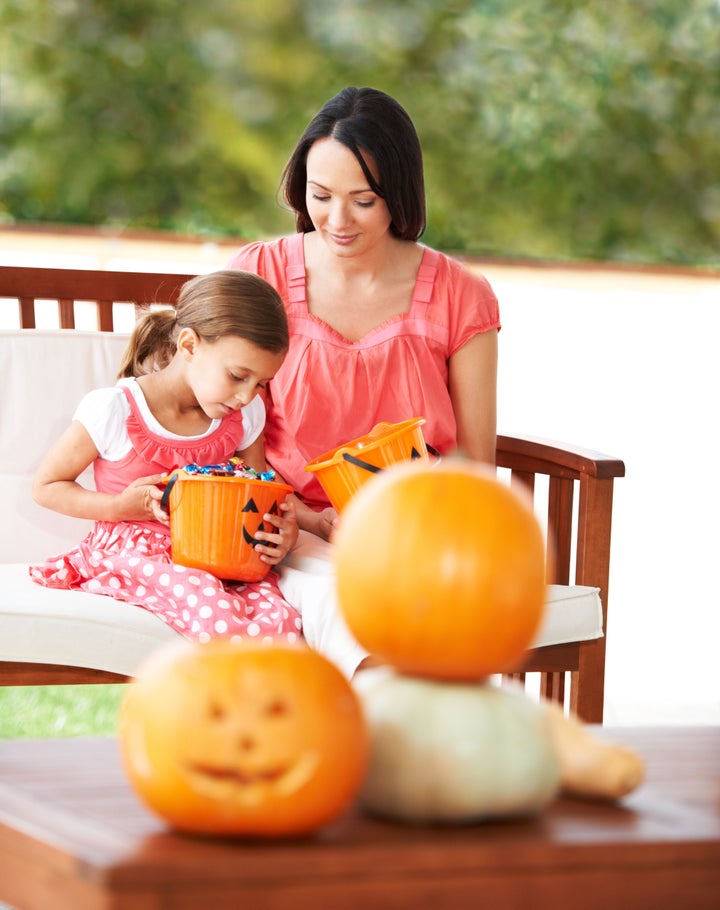 A mother and her daughter looking at Halloween sweets and candy