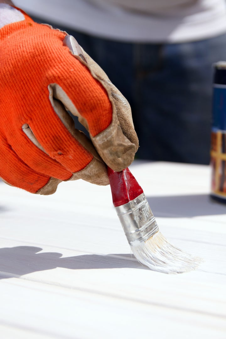 Painting wooden boards with white protective paint with a brush. Do it yourself, DIY