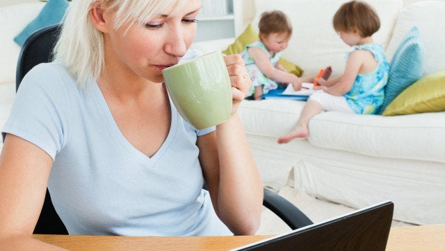 Relaxed working with her children at laptop in living room