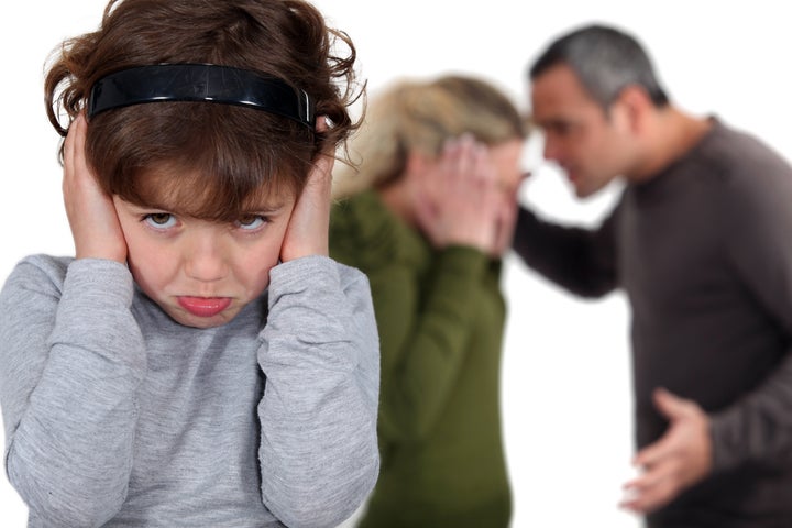 Little girl blocking out her parents' argument