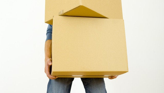 Man holding cardboards. Front view, whole body. Gray background