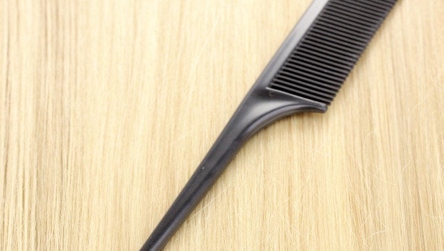 Shiny blond hair with hair comb close-up