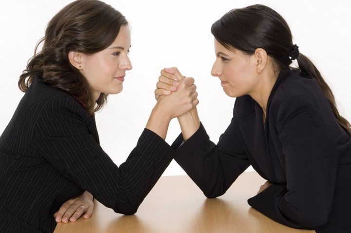two women arm wrestling at work ...