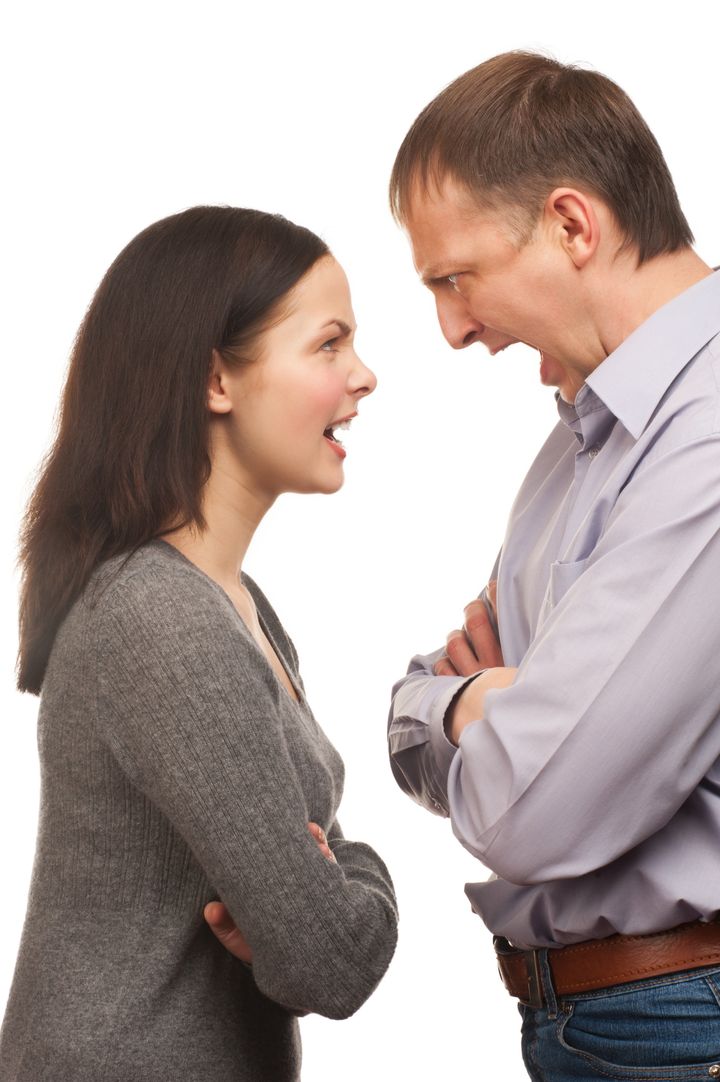 Young couple in quarrel. Wife yelling at her husband, isolated on white background