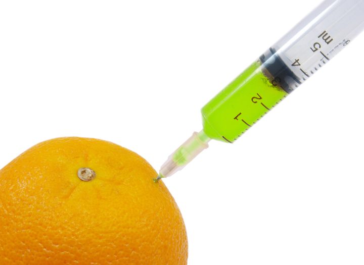 syringe sticked into orange gmo
