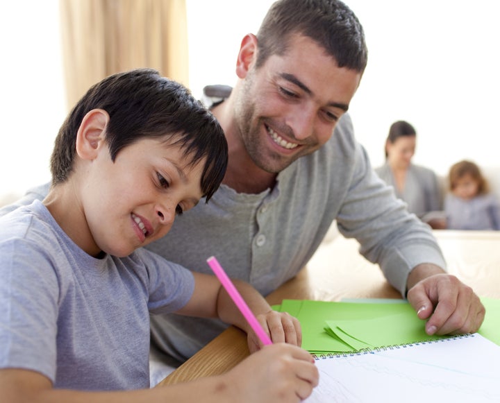 Father helping his son doing homework at home