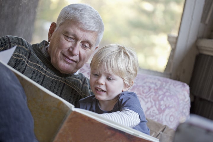 Grandfather reading a book to his grandchild