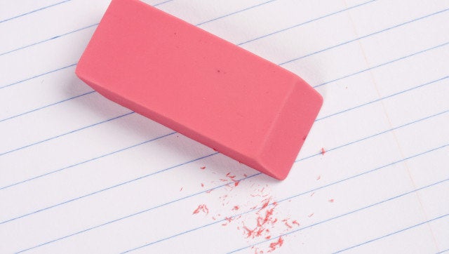 Pink eraser with residue on lined paper.