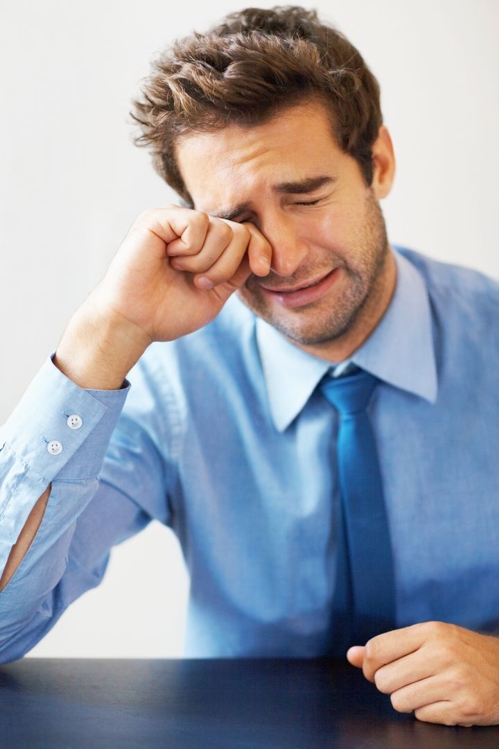 Portrait of young business man crying like child