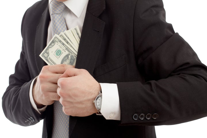 Man in a putting money in his pocket. Isolated over white